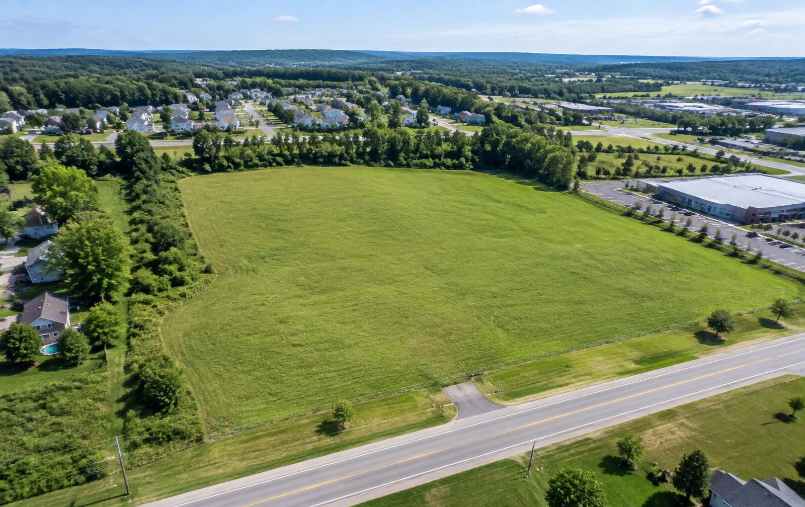 Vacant development land with road access beside residential and commercial properties
